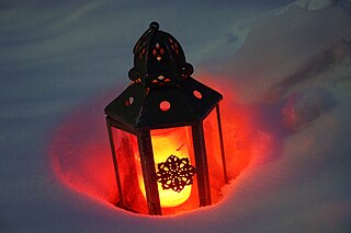 Brennendes Grablicht im Schnee